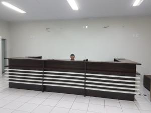 un hombre está sentado en un escritorio en una habitación en Hotel Águia, en Teixeira de Freitas
