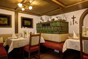 a dining room with two tables and a cross on the wall at Hotel Gemma- Adults only in Hirschegg