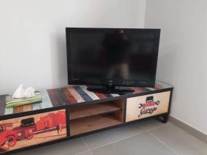 telewizor z płaskim ekranem siedzący na szczycie centrum rozrywki w obiekcie Villa Marianna Garda Lake w mieście Peschiera del Garda