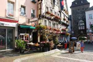 eine Stadtstraße mit Tischen, Stühlen und Gebäuden in der Unterkunft The Burgklause Boutique Hotel in Linz am Rhein