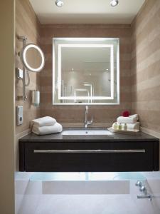 a bathroom with a sink and a large mirror at Land & Golf Hotel Stromberg in Stromberg