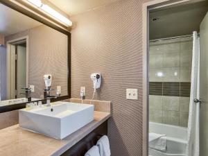 a bathroom with a white sink and a shower at Plaza Hotel & Casino in Las Vegas