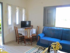 a living room with a blue couch and a table at Santa Rosa do Sul - SC in Sombrio