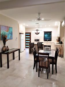 a dining room and kitchen with a table and chairs at Darwin Beach Escape Holiday Home in Casuarina