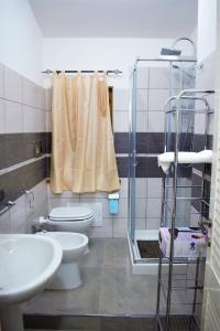 La salle de bains est pourvue de toilettes, d'un lavabo et d'une douche. dans l'établissement Asherat B&B, à Carbonia