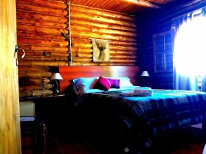 a bedroom with a bed and a wooden wall at Cabañas Sehuen in Uspallata