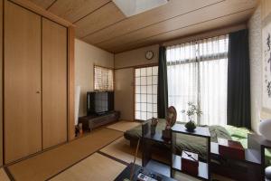a living room with a couch and a tv at Close to Golden temple -Kinkakuji- in Kyoto