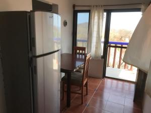 a kitchen with a refrigerator and a table and a balcony at La Casita De Marlen in Puerto Ángel
