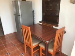 een keuken met een houten tafel en een koelkast bij La Casita De Marlen in Puerto Ángel