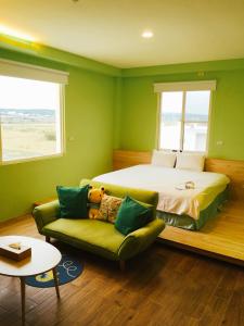 a green bedroom with a bed and a couch at Let's Play B&B 七桃旅宿 in Nanwan