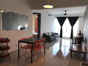 a living room with a table and chairs and a couch at Homestay de Putra in Kajang