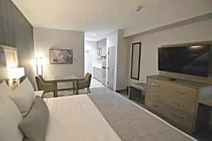 Best Western Plus Executive Residency Oklahoma City I-35 في مدينة اوكلاهوما: غرفة فندقية بسرير وتلفزيون بشاشة مسطحة