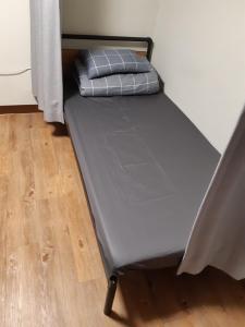 a bed sitting in a room next to a wall at Able Guesthouse Hongdae 2 in Seoul