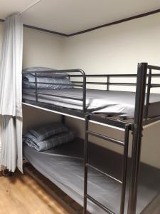 a bunk bed room with two bunk beds and towels at Able Guesthouse Hongdae 2 in Seoul