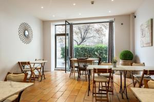 un ristorante con tavoli e sedie e una grande finestra di Hôtel Central ad Avignone