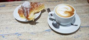 a cup of coffee and a pastry on a table at Sea House Porto Ercole in Porto Ercole
