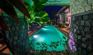 a swimming pool in the backyard of a house at night at The Sanctuary Langkawi in Pantai Cenang