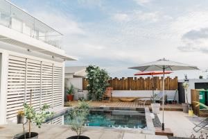 un patio trasero con piscina y sombrilla en Maison TONGA piscine jaccuzi, en Saint-Pierre