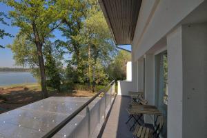 a balcony with benches and a view of a lake at Sirály Panzió Tópart in Tata