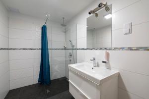 a white bathroom with a sink and a shower at Sirály Panzió Tópart in Tata