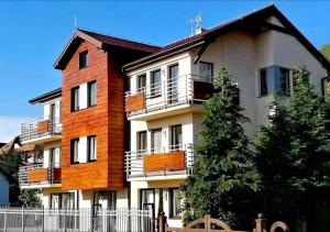 a large building with a white fence in front of it at Apartamenty Międzymorzem in Krynica Morska