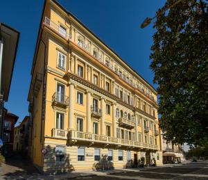 a large yellow building with balconies on a street at Europalace Hotel in Verbania