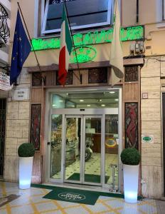 a store front with a glass door and flags on it at Hotel Cavour in Rapallo