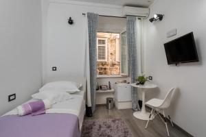 ein Schlafzimmer mit einem Bett, einem Fernseher und einem Fenster in der Unterkunft Guest House Tomasi One in Dubrovnik