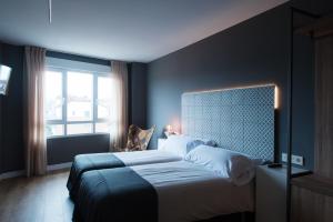 Una cama o camas en una habitación de Rener Hotel Los Campones