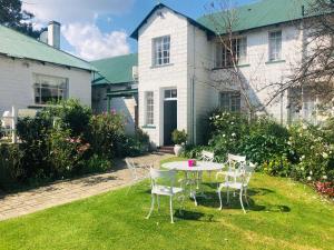 a table and chairs in the yard of a house at Green Lantern Inn in Van Reenen