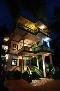 a large building with stairs and balconies at night at Casa Margarida in Calangute