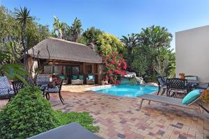 a pool with chairs and a gazebo at Atlantic Breeze in Cape Town