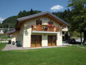 a house with a balcony with flowers on it at Ai Vecchi Molini in Castello Tesino