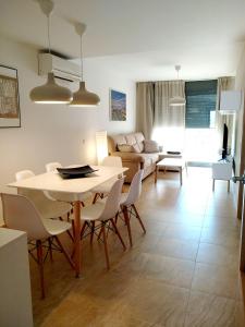 a living room with a table and chairs and a couch at Mi Apartamento en el Delta del Ebro+ in Deltebre