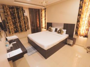 - une chambre avec un lit, une table et des rideaux dans l'établissement Travelling Troopers Homestay, à Varanasi