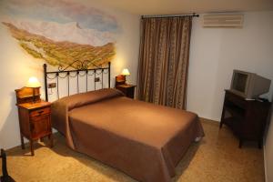 Säng eller sängar i ett rum på Hotel Puerta Nazarí