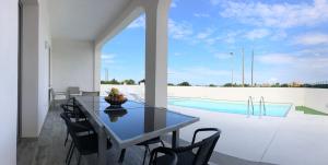 a dining room with a table and a swimming pool at Casa Vacanza Gemini in Marsala