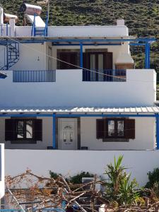 a white house with blue trim at Karabo Hotel in Livadi Astypalaias