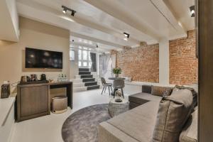 a living room with a brick wall at Luxury Canal Suite De Heren in Amsterdam