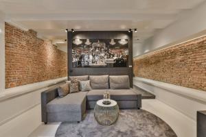 a living room with a couch and a brick wall at Luxury Canal Suite De Heren in Amsterdam