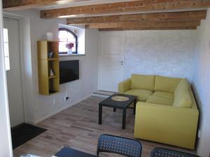a living room with a yellow couch and a table at stixered fegen in Fegen