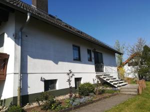 a white building with stairs on the side at Ferienwohnung am Riedrain in Eichenzell