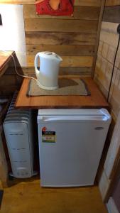 a white refrigerator freezer sitting on top of a wooden table at Alice's Secret Travellers Inn in Alice Springs