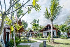 a house with palm trees in front of it at Kashantee Village in Seminyak