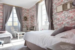 - une chambre avec un grand lit et du papier peint floral dans l'établissement Château de Puy Robert LASCAUX - Sarlat, à Montignac