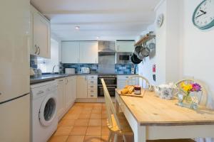 a kitchen with a table and a sink and a dishwasher at Whistler's Rest in St Ives