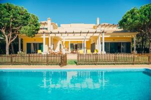 a house with a swimming pool in front of a house at Casa da Praia Verde in Praia Verde