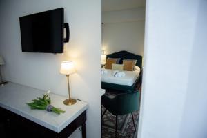 una camera d'albergo con un letto e una televisione di Suite35 a Catania