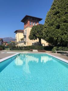 uma piscina em frente a um edifício com uma torre em Villa Vitali - Bellagio em Bellagio