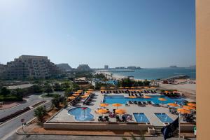 an overhead view of a pool with umbrellas and the ocean at City Stay Beach Hotel Apartments - Marjan Island in Ras al Khaimah